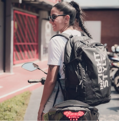 Stylish athlete wearing the Ultimate Urban Trainer Backpack by InfightStyle, ready for training on a motorcycle.
